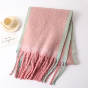 Close-up of pink and mint green gradient fringe scarf with beige coffee cup on table