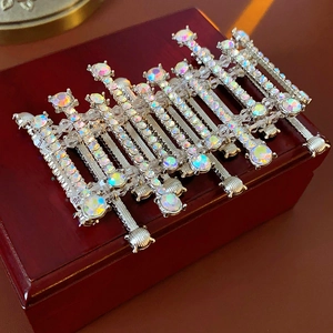 Detailed macro view of silver alloy hair clips with iridescent AB rhinestones on wood