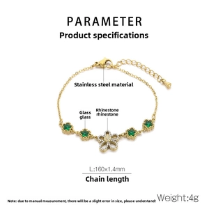 Detail view of gold stainless steel bracelet with green star stones and floral charm
