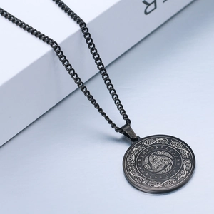 Macro detail of black metal Viking rune pendant with Celtic knot and Triskele engraving