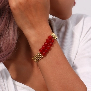Detail of red natural stone beads paired with a gold stainless steel watchband chain