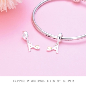 Macro view of S925 sterling silver A-letter charm with gold heart on engraved bangle