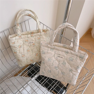 Détails des sacs à main matelassés à fleurs avec étiquettes simples dans un panier