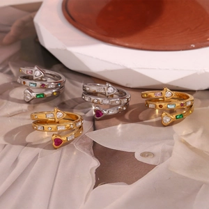 Detail of spiral open rings with multi-color heart and arrow zircon stones on a white base
