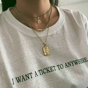 Layered gold necklaces with letter D pendant and dragon relief charm on a model