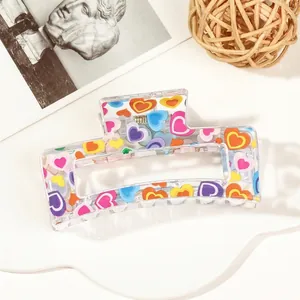 Detail of transparent square hair claw with colorful heart prints and metal spring