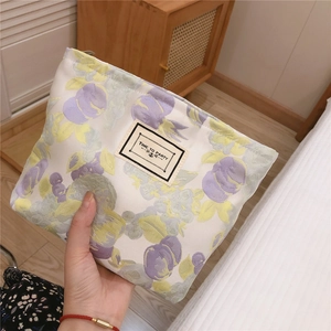 Macro detail of floral canvas makeup bag with woven texture and vintage woven label