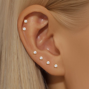 Detailed macro shot of six-piece minimalist gold S925 silver stud earring set on ear