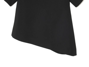 Vue détaillée de l'ourlet asymétrique de ce haut noir élégant à manches bouffantes
