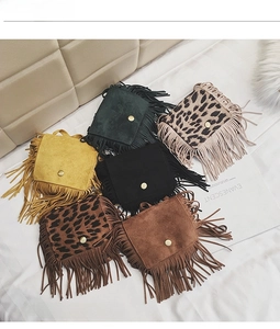 Flat lay of colorful fringe mini crossbody bags for kids in solid colors and leopard prints