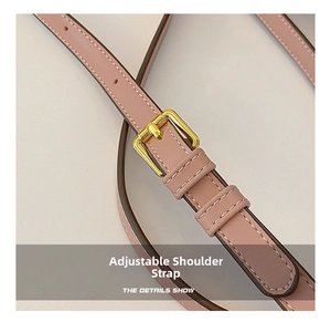 Close-up of pink leather adjustable shoulder strap with golden metal buckle and stitching