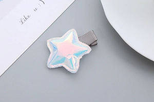 Detail of star-shaped hair clip with pink iridescent finish and white faux fur trim