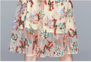 Close-up of elegant floral embroidery on mesh fabric of the lightweight dress hem
