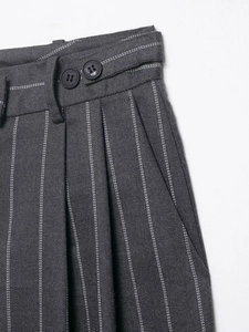 Detail of grey pinstripe trousers featuring double-button waist and pleated design