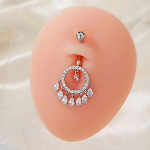 Detail eines silbernen Bauchnabelpiercings mit Zirkonia-Kreis und Wassertropfen