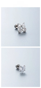 Macro detail of silver zircon stud earrings featuring heart and cherry designs