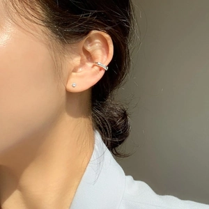 Close-up of minimalist S925 silver four-claw zircon stud earrings on model's ear