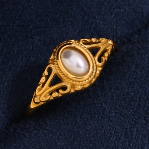 Minimalist gold plated stainless steel floral pearl ring on blue velvet background