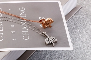 Detail view of hollow Tree of Life pendants in rose gold and silver stainless steel