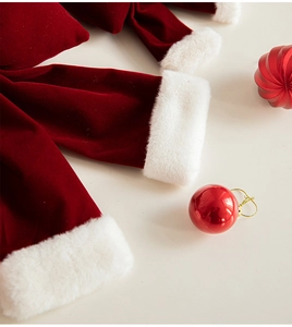 Close-up of burgundy velvet Christmas bow with soft white faux fur trim and holiday decor