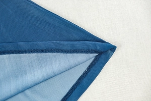 Detailed macro view of the fine blue mesh fabric and high-quality overlock stitching
