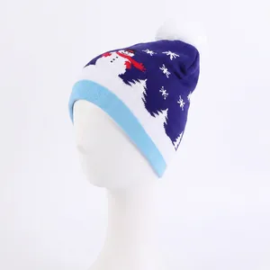 Detail view of the winter knitted hat with snowman jacquard and white pompom on top