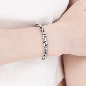Close-up of minimalist titanium steel link bracelet on wrist with bright silver finish