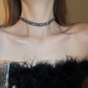 Close-up of a dark gunmetal choker necklace with shimmering rhinestones on a model