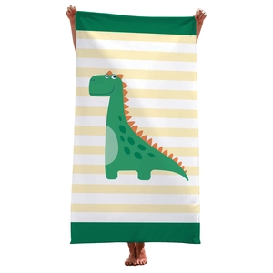 Detail of green striped microfiber beach towel with cute dinosaur cartoon print held by model