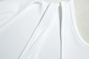 Detailed macro view of white shoulder straps with fine ribbed texture and seam stitching