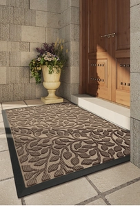 Detailed texture of brown door mat with leaf pattern and durable black rubber border
