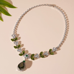 Detail einer Vintage-Halskette mit grünem Tropfen-Edelstein und Zirkon-Blättern