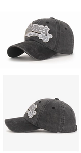 Detail view of washed vintage cotton baseball cap with embroidered patch and metal buckle