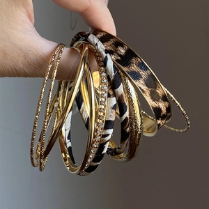Detail of 10-piece metal and leather bracelet set with leopard print and crystals
