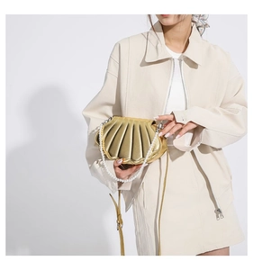 Detail der muschelförmigen Handtasche mit Gold-Finish und elegantem Perlengriff