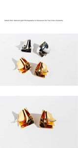 Detail shot of modern irregular layered geometric metal stud earrings in polished gold