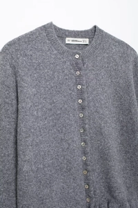 Detail of grey knit cardigan featuring pearl buttons and soft mohair texture