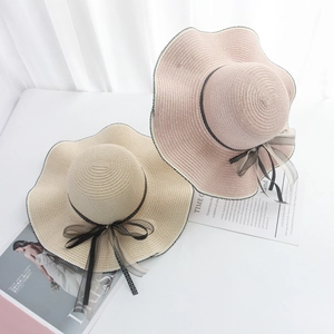 Stylish beige and pink wide brim straw hats with wavy edges and polka dot ribbon bows