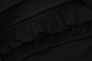 Détail du tissu en maille noire avec texture plissée élastique et couture précise