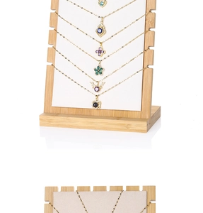 Detail of bamboo wood necklace display stand with white velvet lining for jewelry storage