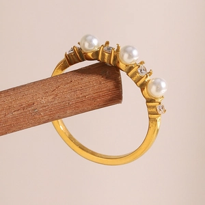 Gold-plated stainless steel ring featuring three white pearls and clear zircon accents