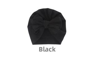 Detail of black infant turban hat with a large double-layer bow and pleated cotton fabric