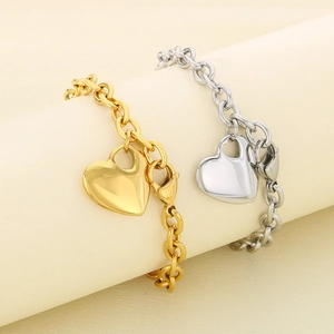 Modern gold and silver heart pendant bracelets with polished link chains on stands