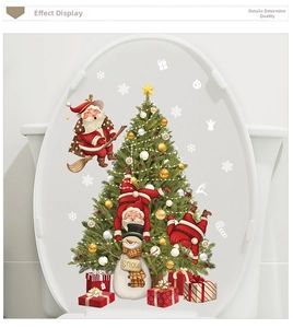 Detail view of Santa Claus and Christmas tree stickers on a white toilet lid