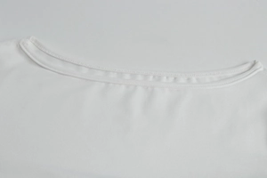 Dettaglio dello scollo con cuciture precise a doppio ago su abito in maglia bianco