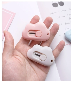 Mini cloud-shaped utility knives in pink and white held by hand for unboxing tasks