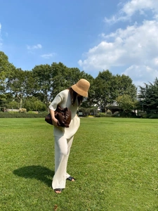 Detail of a handmade raffia bucket hat paired with a beige knit summer set for women