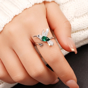 Detail van verstelbare kolibrie ring met groene peervormige edelsteen en kristallen