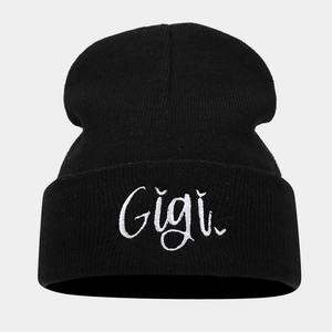 Close-up of Gigi embroidery on black knit beanie with fine stitching details
