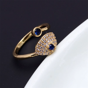 Macro shot of an adjustable evil eye ring in gold with micro-pave crystals and blue stones